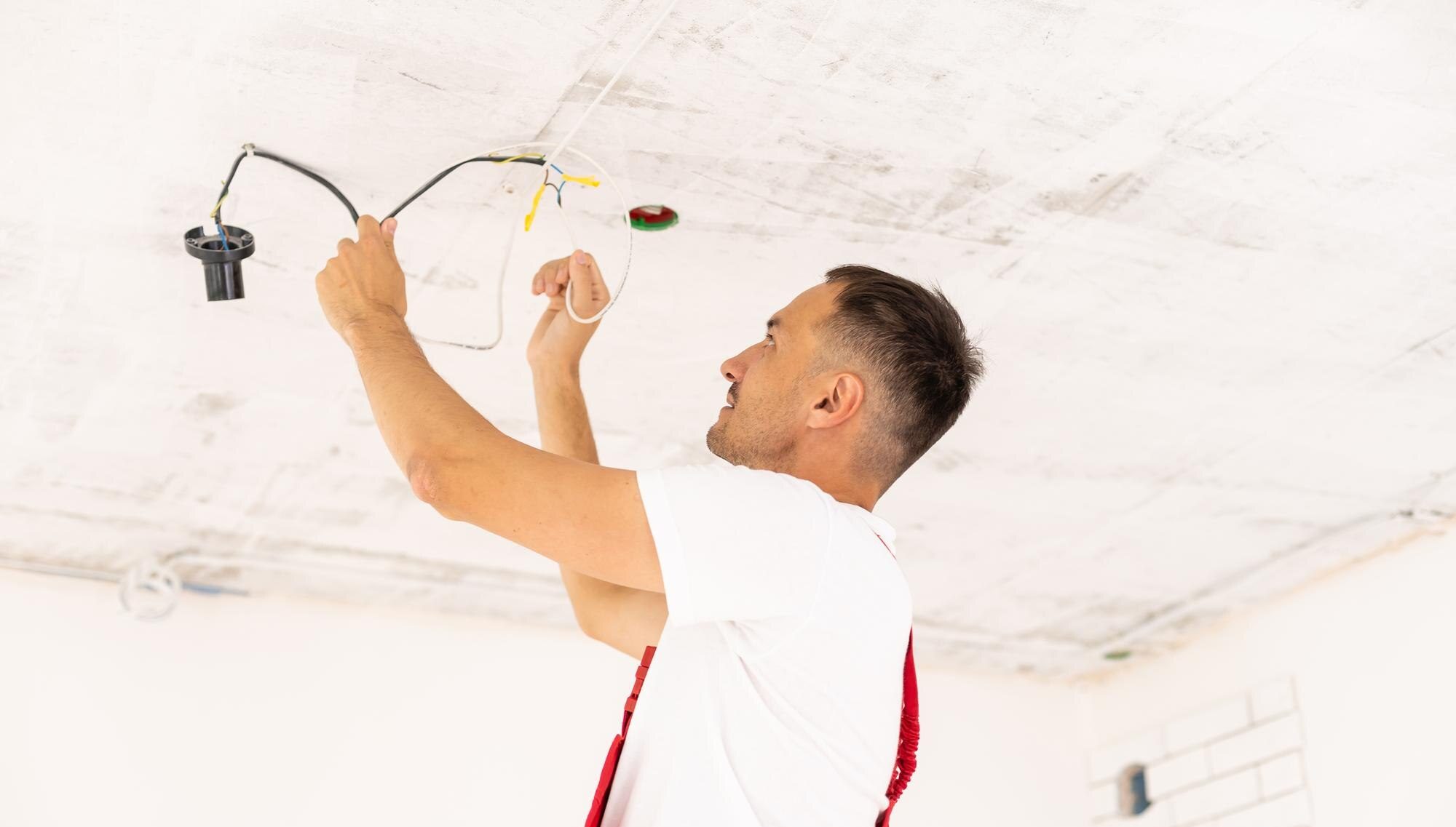 repair renovation electricity people concept close up builder electrician running wires indoors 4933 e1744129277946