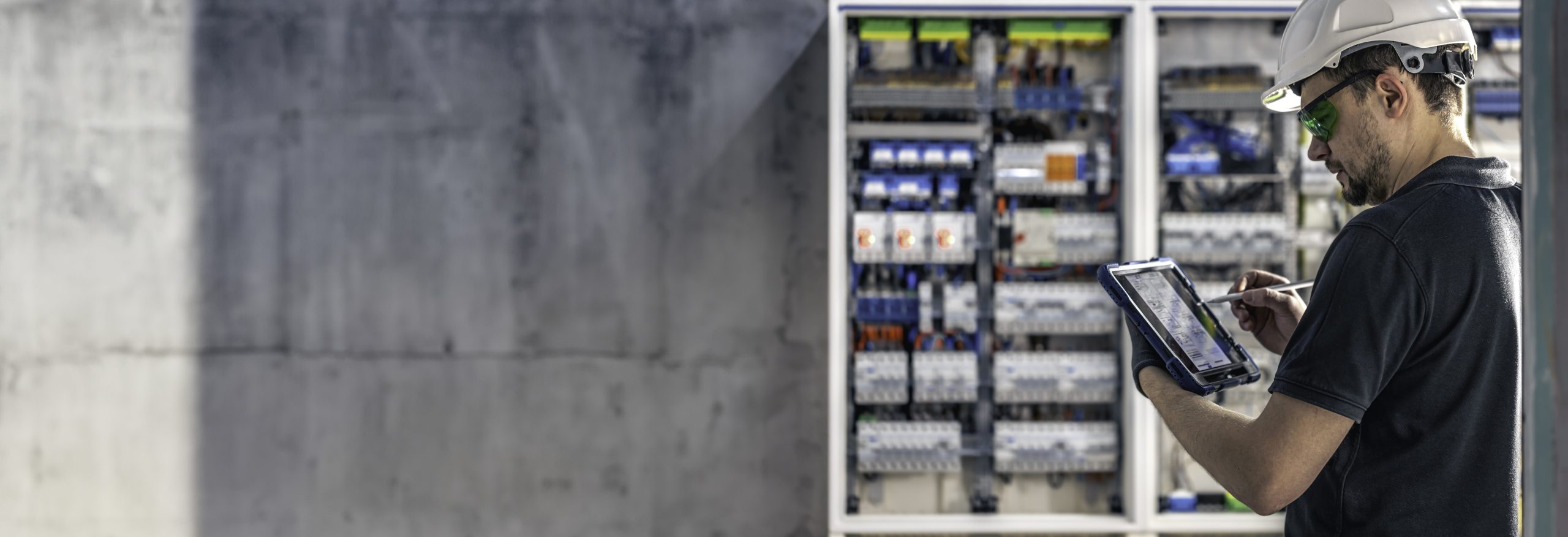Man, an electrical technician working in a switchboard with fuses.